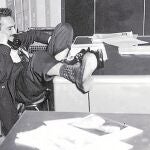 AÑOS CINCUENTA. Un teléfono, los pies sobre la mesa, folios revueltos. García Márquez en estado puro. A la derecha, página de «El espectador» con «Relato de un naúfrago»