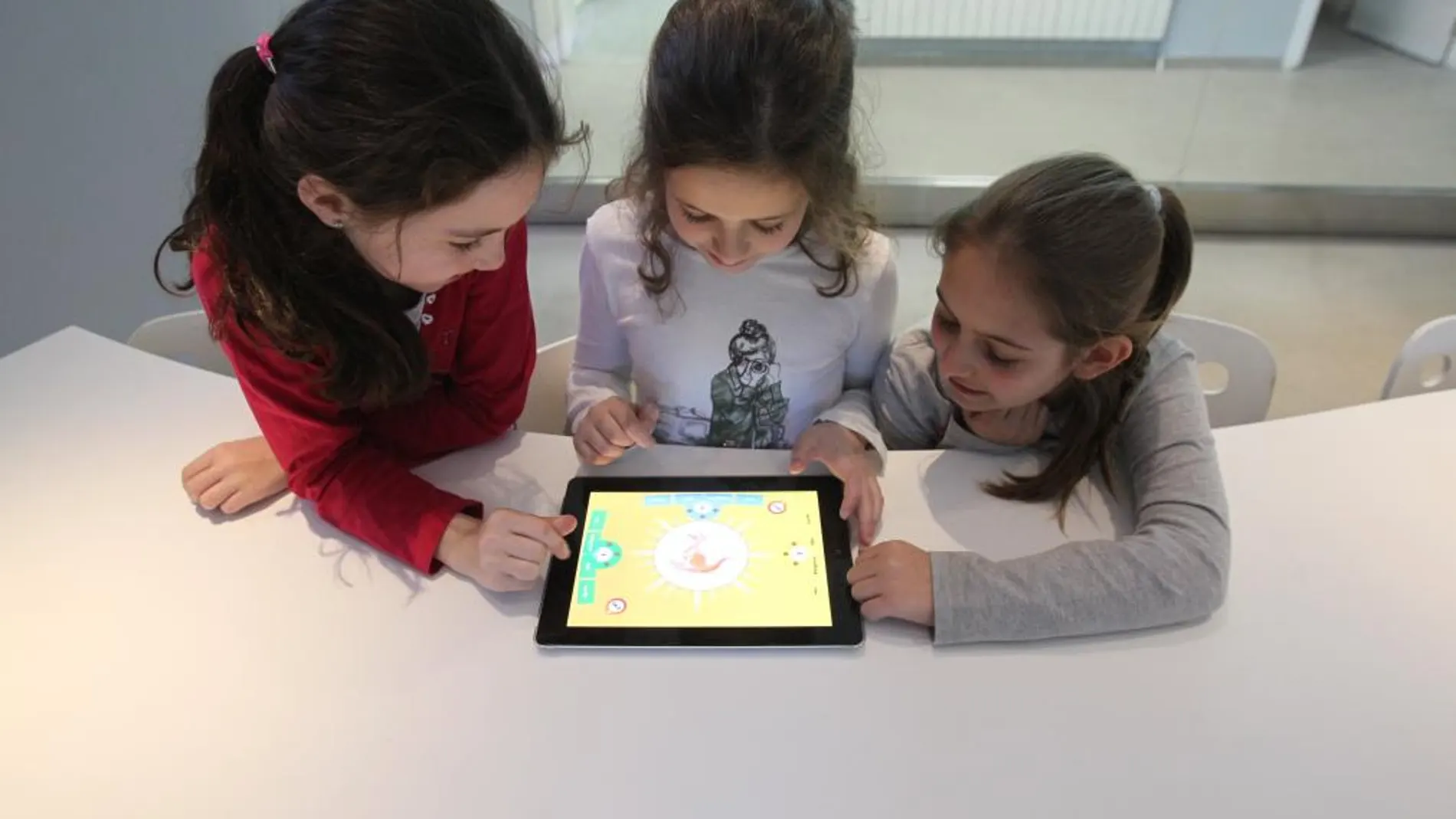 Tres niñas jugando con una tableta