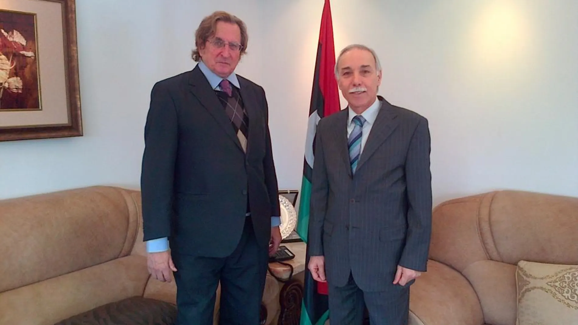 Don Joaquín Antuña, Presidente de Paz y Cooperación y el embajador de Libia en España (izq.) don Mohamed Alfaqeeh Saleh, ambos delante de la bandera de este país