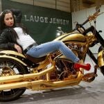 Una modelo posa sobre la Harley Davidson bañada en oro