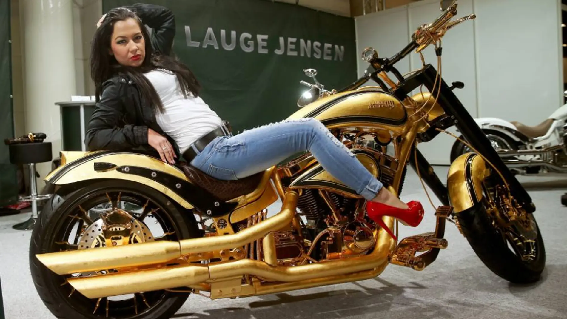 Una modelo posa sobre la Harley Davidson bañada en oro