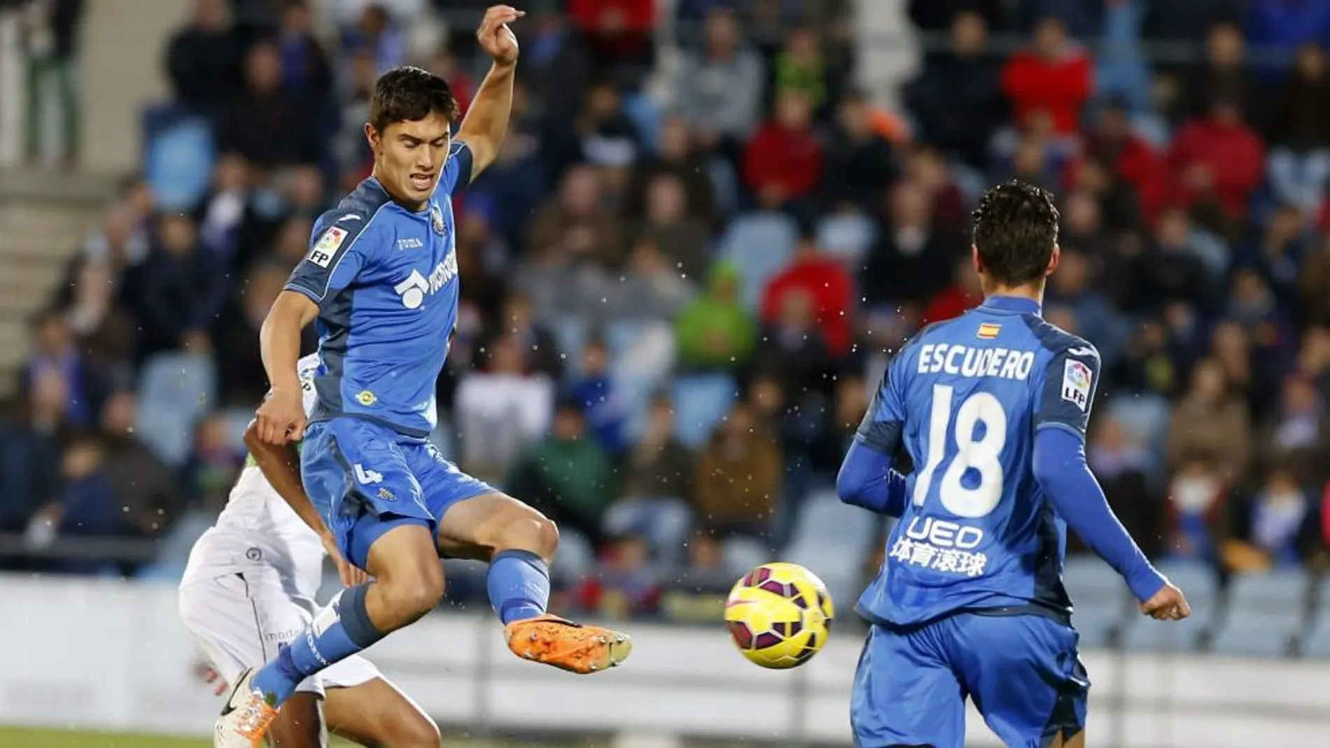 El defensa uruguayo del Getafe Emiliano Daniel Velázquez golpea el balón ante su compañero, Sergio Escudero durante el partido correspondiente a la undécima jornada de Liga de Primera división