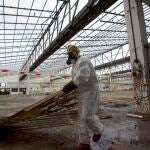 Un operario retira ruinas industriales contaminadas de amianto en el País Vasco