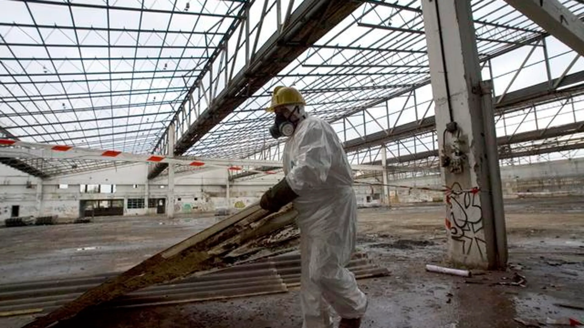 Un operario retira ruinas industriales contaminadas de amianto en el País Vasco