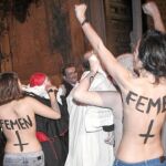 Cinco activistas de Femen, ayer, en el momento en el que abordan y arrojan bragas manchadas de rojo a Rouco Varela
