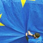 Un trabajador coloca una bandera de la UE en Bruselas en 2004