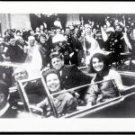 John y Jackie Kennedy sonríen a la cámara durante su paseo por las calles de Dallas, minutos antes del magnicidio
