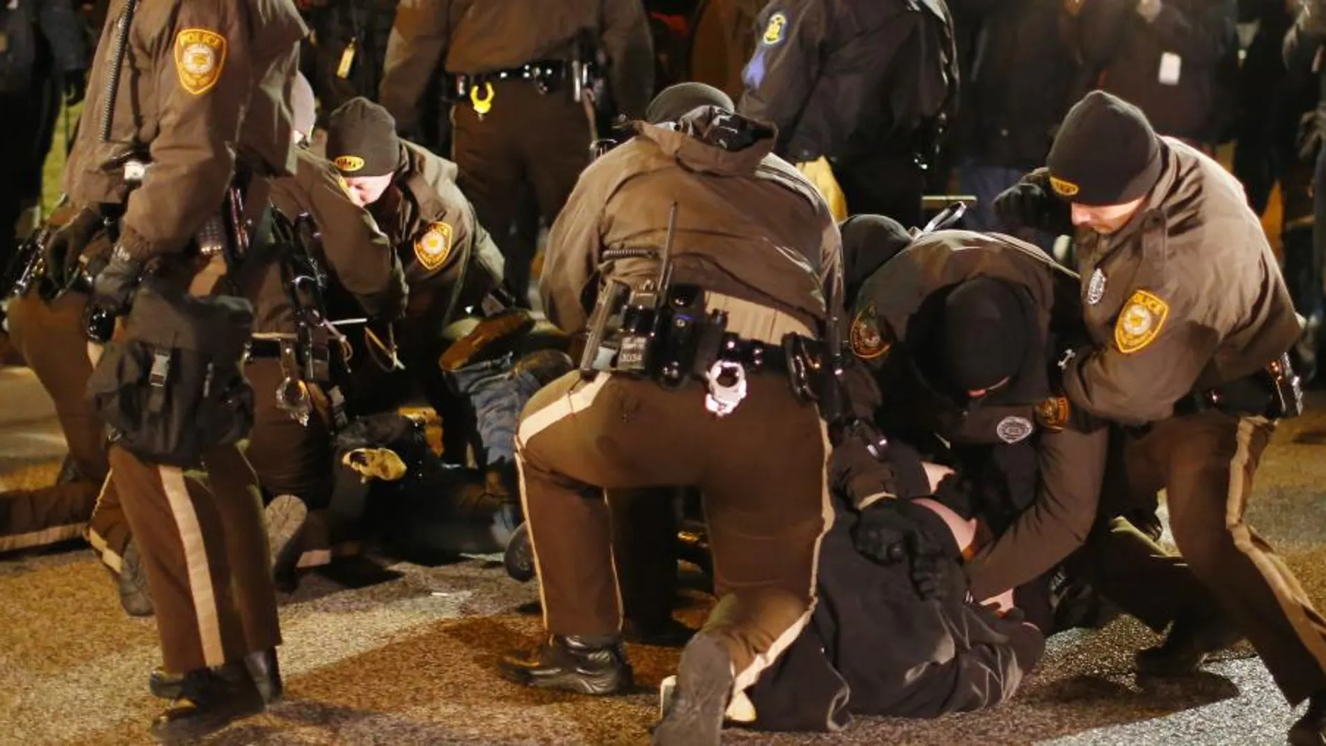 Varios policías detienen a unos manifestantes a las afueras del Departamento de Policía de Ferguson