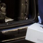 Técnicos y policía científica guardan en el maletero de un coche la caja negra (de color naranja) del tren siniestrado