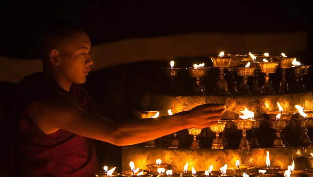 Un monje enciende velas en un templo de Lhasa