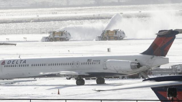 Máquinas quitanieves trabajan en una de las pistas del aeropuerto JFK de Nueva York, el viernes