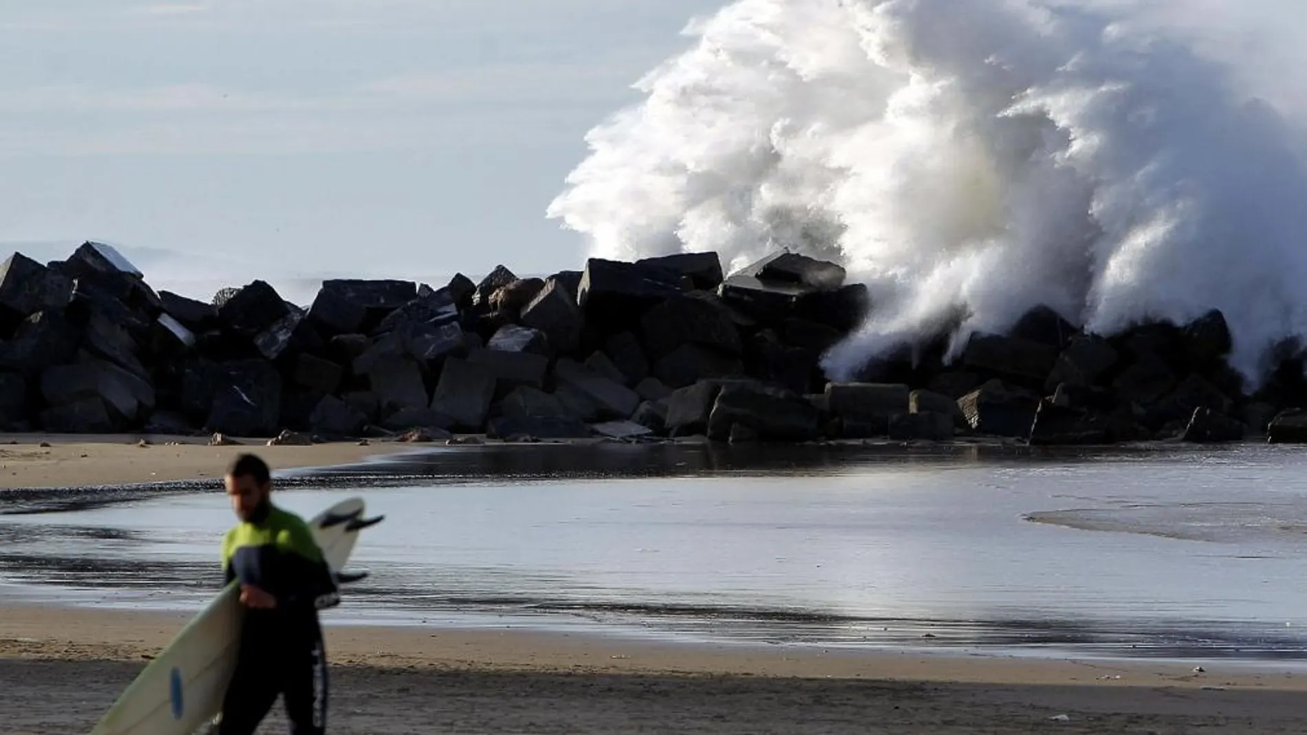 Un surfista sale del agua hoy en la playa de La Zurriola de San Sebastián, donde ya se notan las grandes olas causadas por el temporal que se acerca a la península