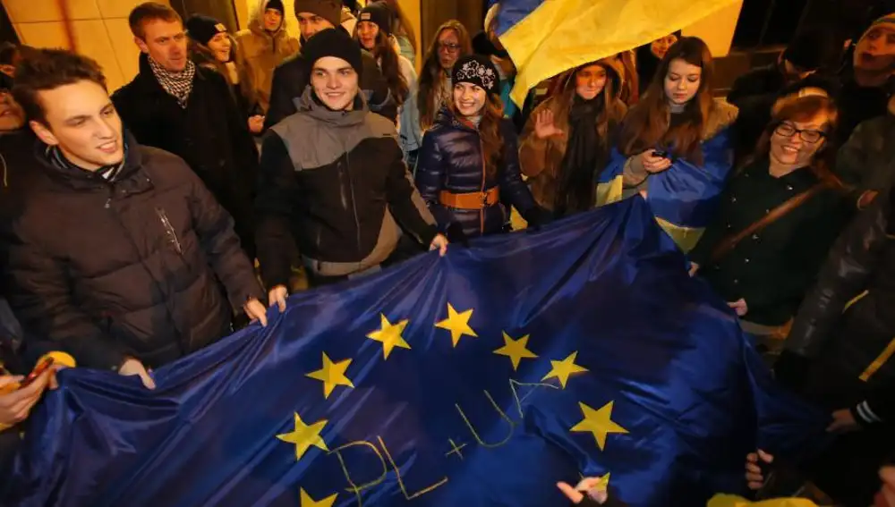 Manifestantes posan con la bandera Europea y de Ucrania durante una manifestación frente a la embajada de Ucrania en Varsovia (Polonia).