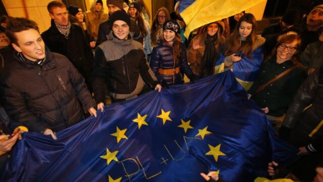 Manifestantes posan con la bandera Europea y de Ucrania durante una manifestación frente a la embajada de Ucrania en Varsovia (Polonia).