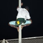 Un inmigrante de origen subsahariano intenta saltar la valla para entrar en Melilla.