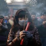 Una mujer ofrece oraciones en Pekín para celebrar el Año Nuevo Lunar