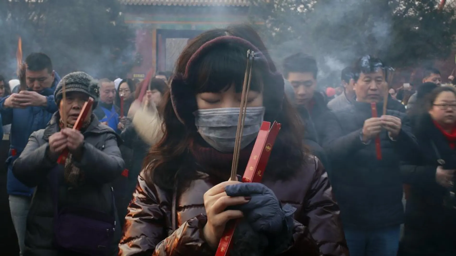 Una mujer ofrece oraciones en Pekín para celebrar el Año Nuevo Lunar