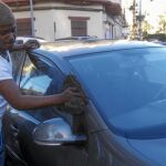 Omar, guineano de 23 años, lava un coche en las calles de Melilla