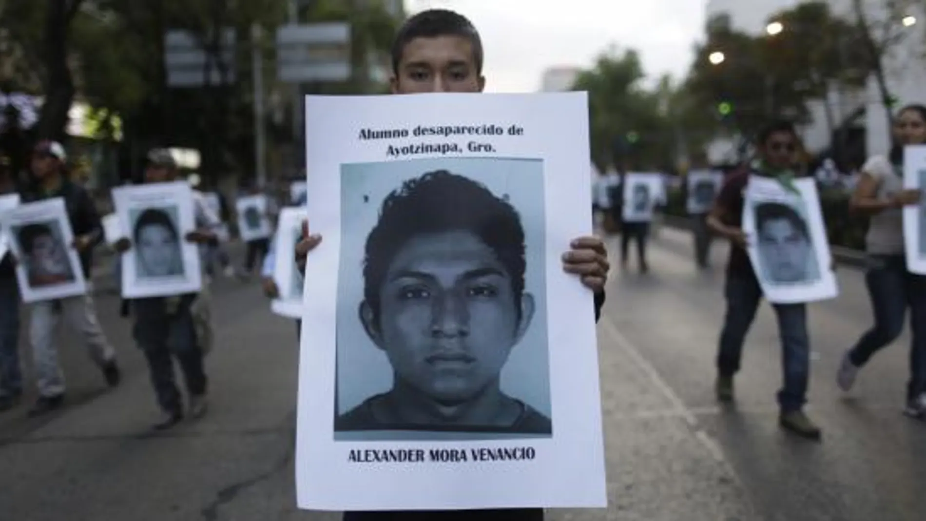 Un manifestante porta un cartel con la fotografía de Alexander Mora Venancio, el estudiante indentificado por los restos