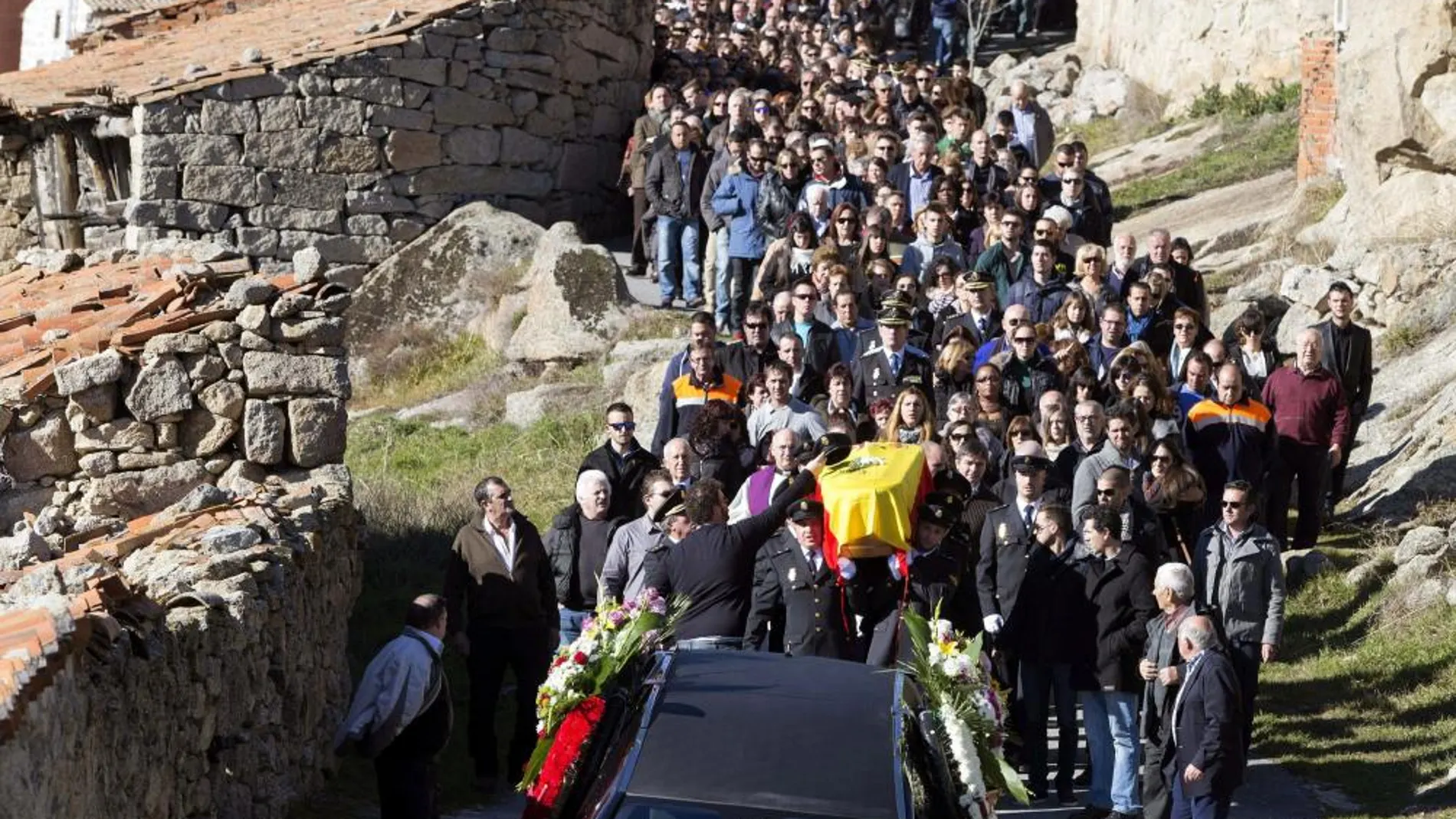Varios compañeros portan el féretro durante el funeral y entierro celebrado hoy en Navarredondilla (Ávila)