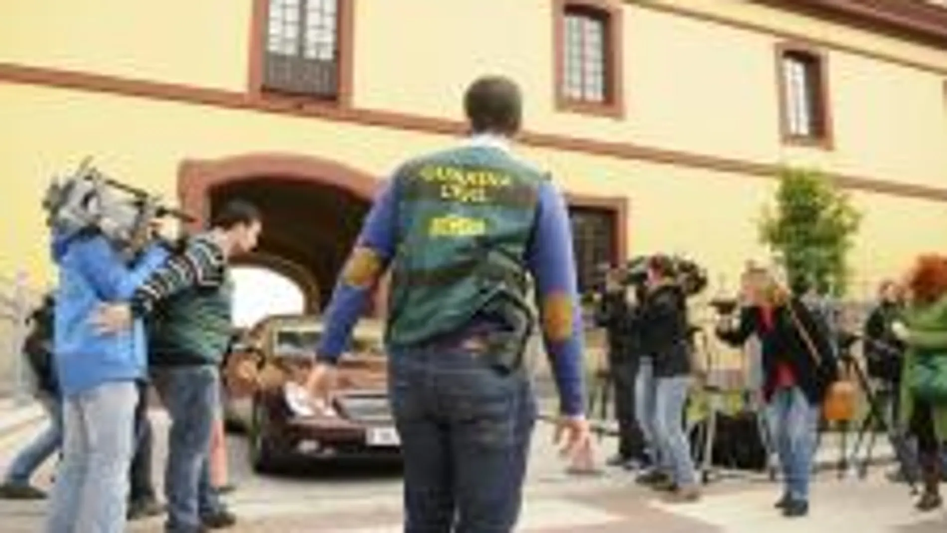 Agentes de la Unidad Central Operativa (UCO) de la Guardia Civil protegen la salida de un vehículo en la sede de la Diputación Provincial de Sevilla