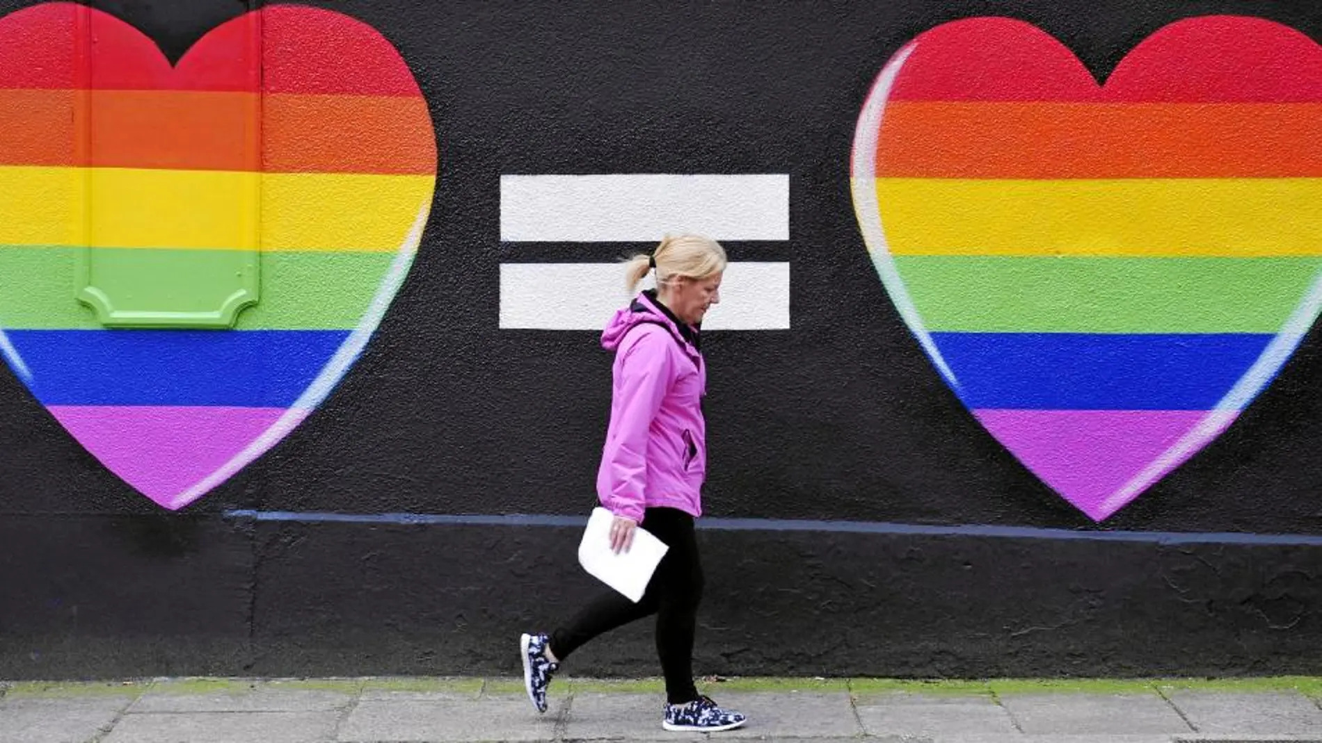 Una mujer pasea frente a un grafiti a favor de los enlaces gays, ayer, jornada de la votación