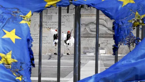 Una bandera quemada de la UE ondea en la tumba del Soldado Desconocido, en la plaza Syntagma de Atenas