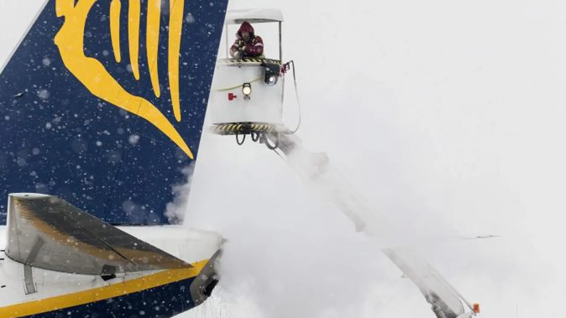 Operarios del aeropuerto trabajan quitando el hielo de un avión de Ryanair en el aeropuerto de Polonia