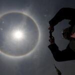Un hombre fotografía el halo solar visible en la ciudad de México este jueves