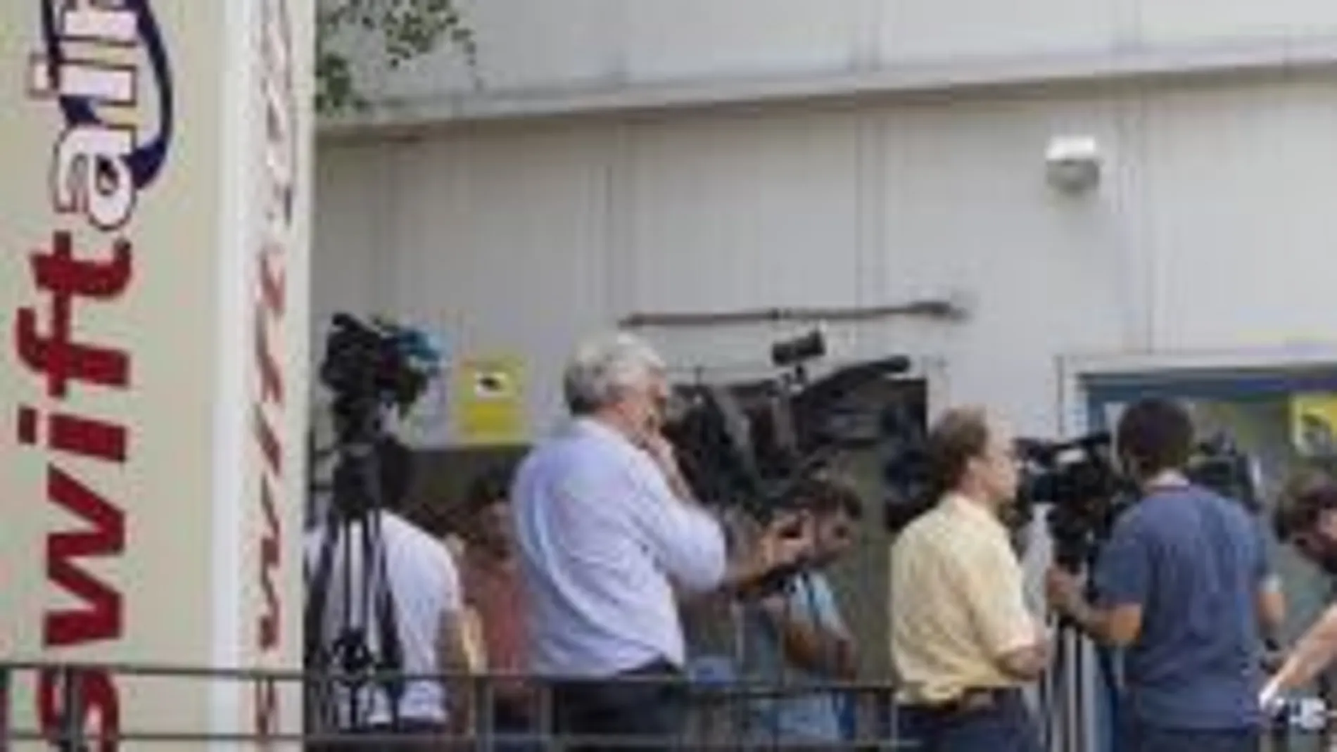 Periodistas en la puerta de sede de Swiftair, en Madrid.