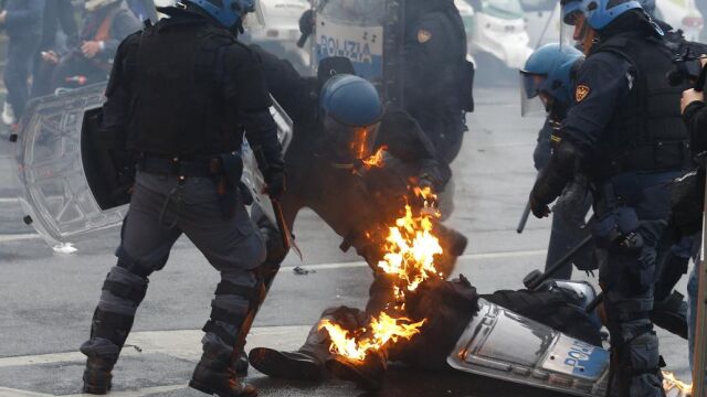 Un agente permanece en el suelo tras recibir el impacto de un cóctel molotov.