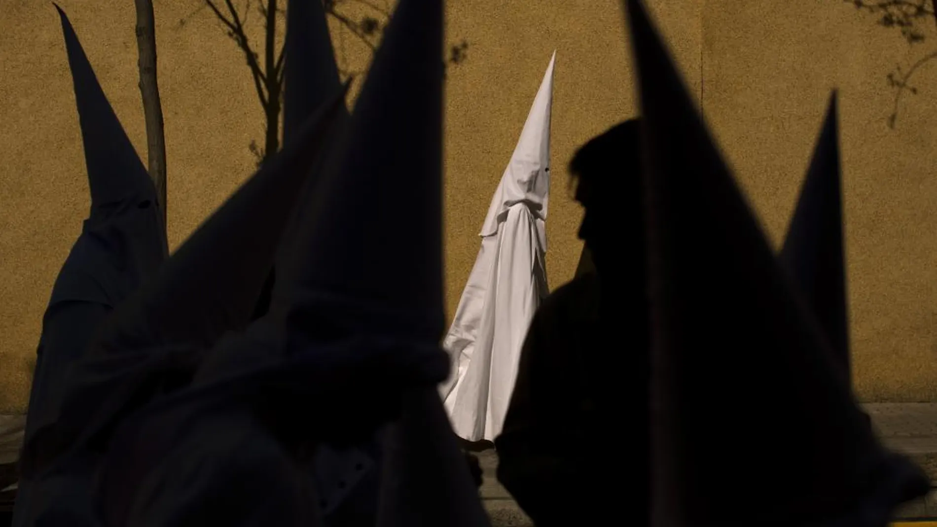 Una nazareno camina por una calle de Sevilla en la Semana Santa del año pasado