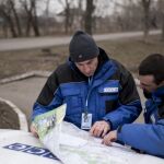 Miembros de la OSCE en Ucrania observan un mapa de la zona.