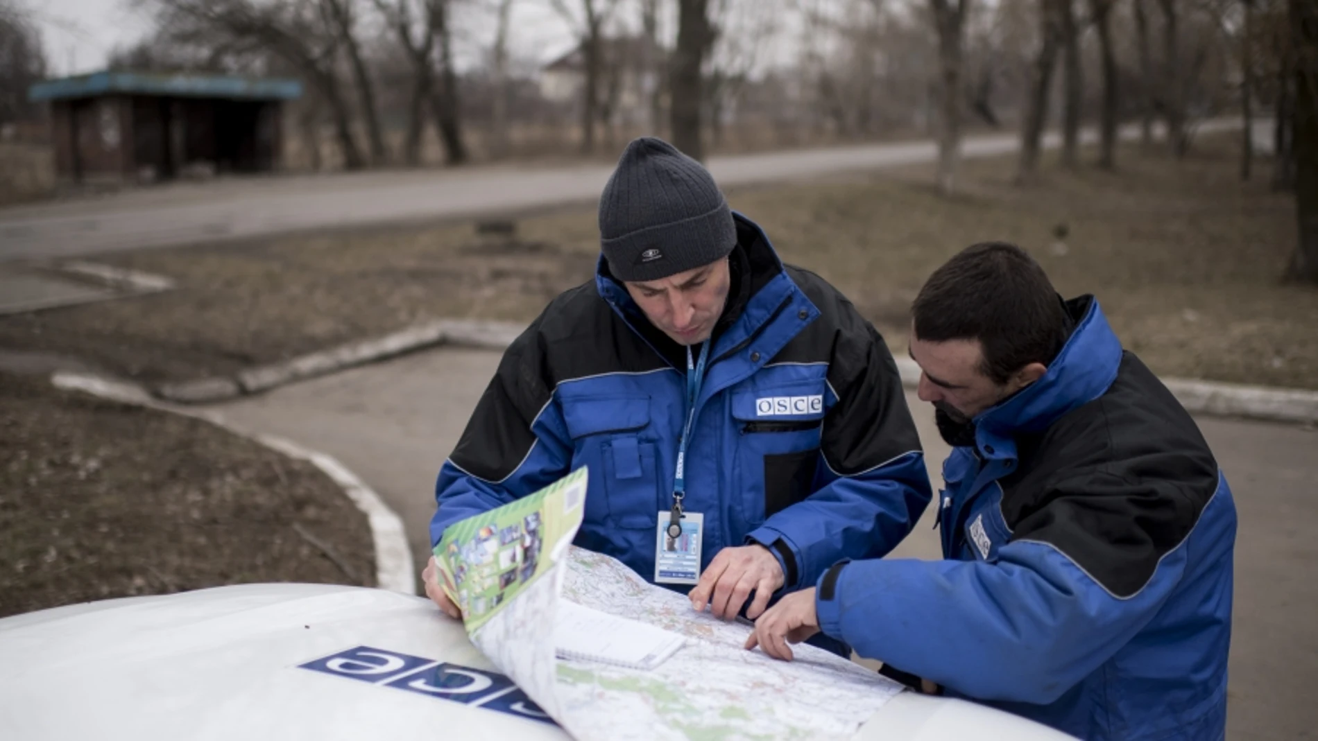 Miembros de la OSCE en Ucrania observan un mapa de la zona.