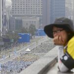 Una joven coreana contempla la beatificación desde una azotea en Seúl