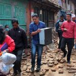 Residentes transportan artículos salvados de sus casa destruidas por el terremoto.