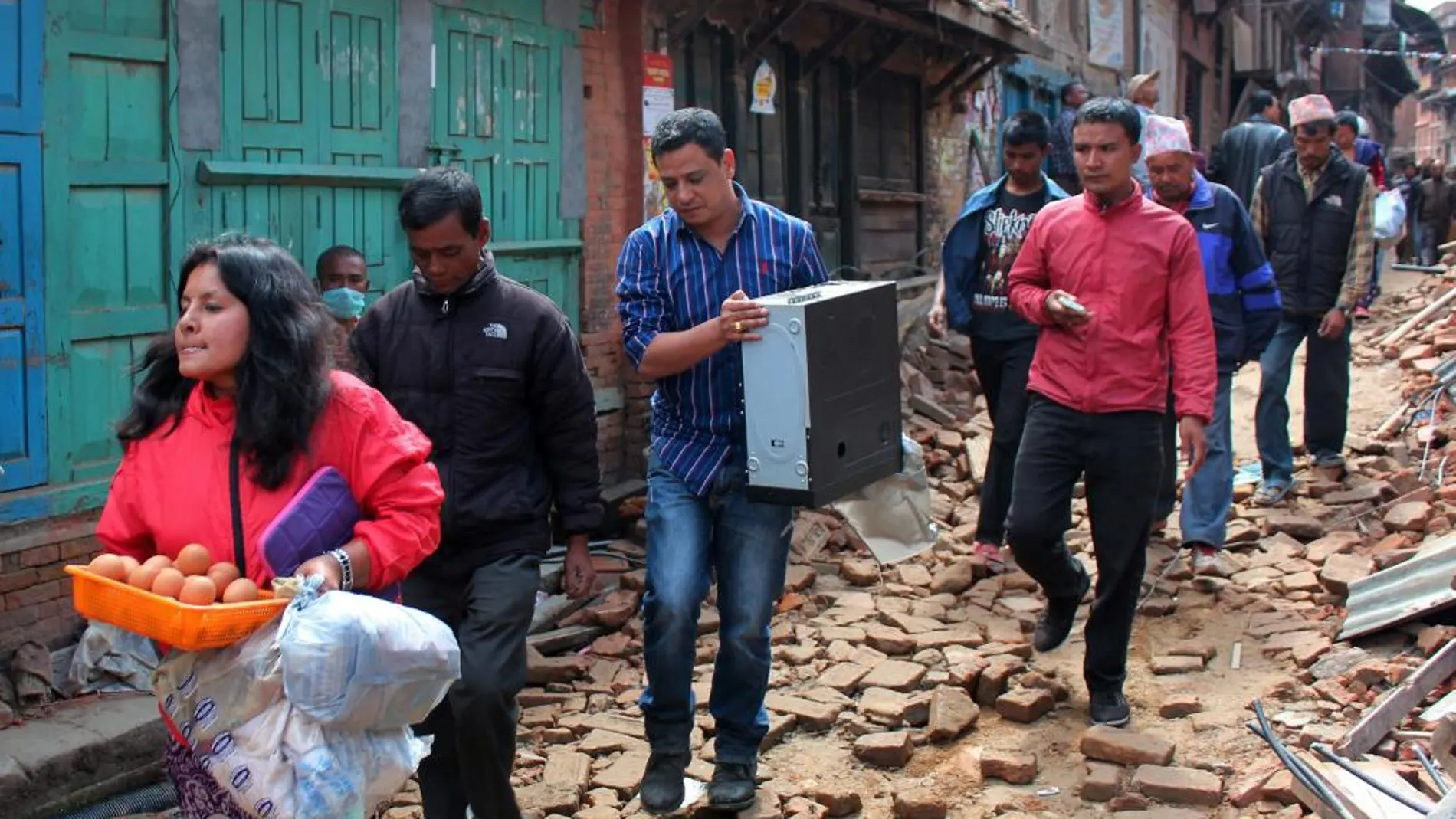 Residentes transportan artículos salvados de sus casa destruidas por el terremoto.