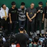 Joshua Wong, líder del movimiento estudiantil, habla con los medios mientras los manifestantes bloquean las inmediaciones de la sede del Gobierno en Hong Kong