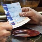Una persona paga con vales de comida en un restaurante.