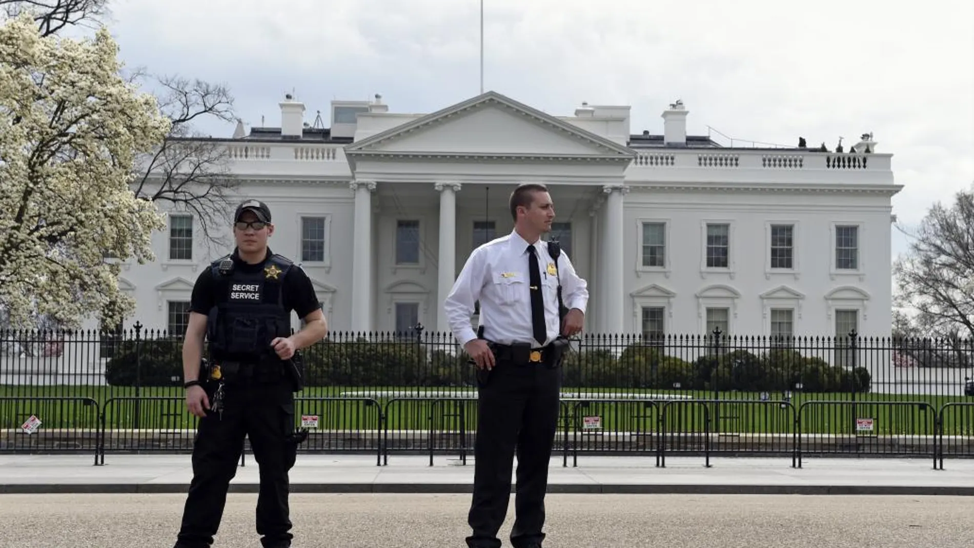 Miembros del servicio secreto vigilan ante la Casa Blanca durante el apagón que ha tenido lugar hoy.