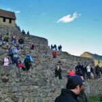 Turistas contemplan el amanecer en Machu Picchu.
