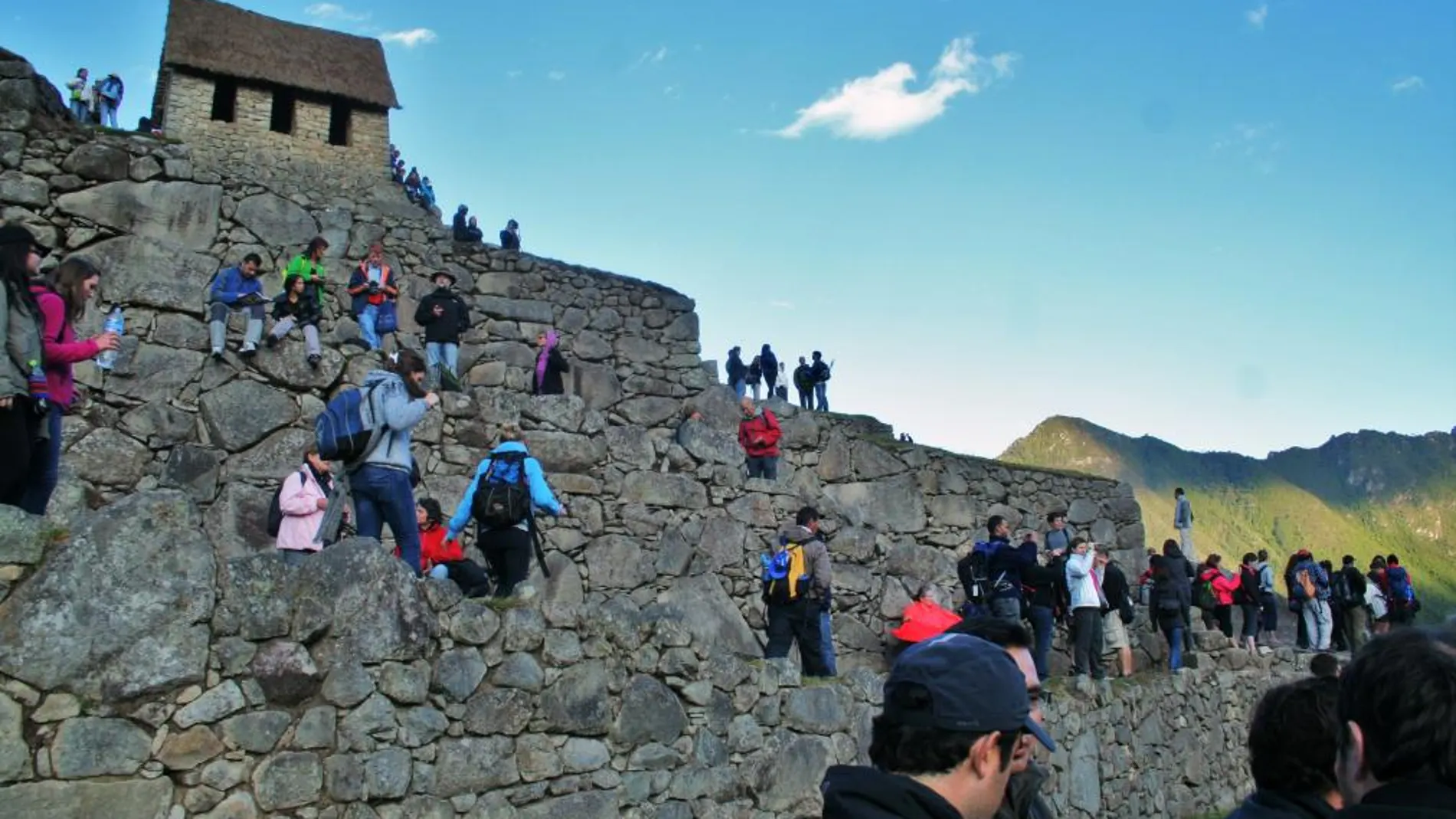 Turistas contemplan el amanecer en Machu Picchu.
