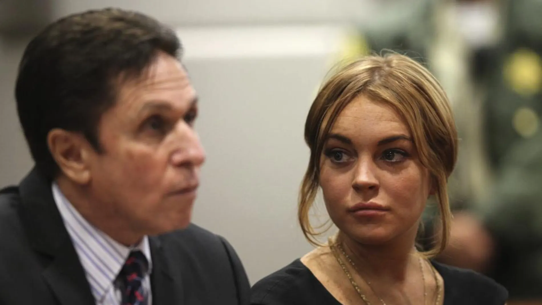 La actriz estadounidense Lindsay Lohan (d), fotografiada junto a su abogado, Mark Heller (i), durante una vista previa a su juicio en un tribunal de Los Ángeles
