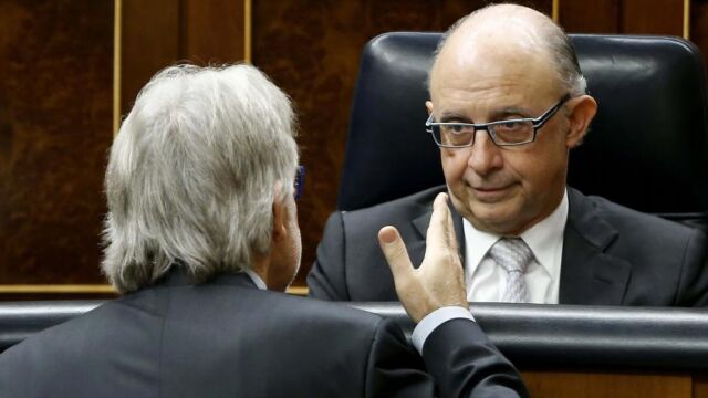 Cristóbal Montoro, conversa con el diputado de CiU Josep Sánchez Llibre (de espaldas), hoy en el Congreso, durante el debate sobre el proyecto de ley de Presupuestos Generales del Estado 2015.