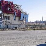 Una ucraniana camina delante de una casa destrozada por los combates que siguen activos al este de Ucrania