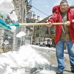 Un vecino de Castellar de N¿Hug retira nieve de la puerta de su casa tras la nevada que obligó a corta la carretera de acceso al municipio
