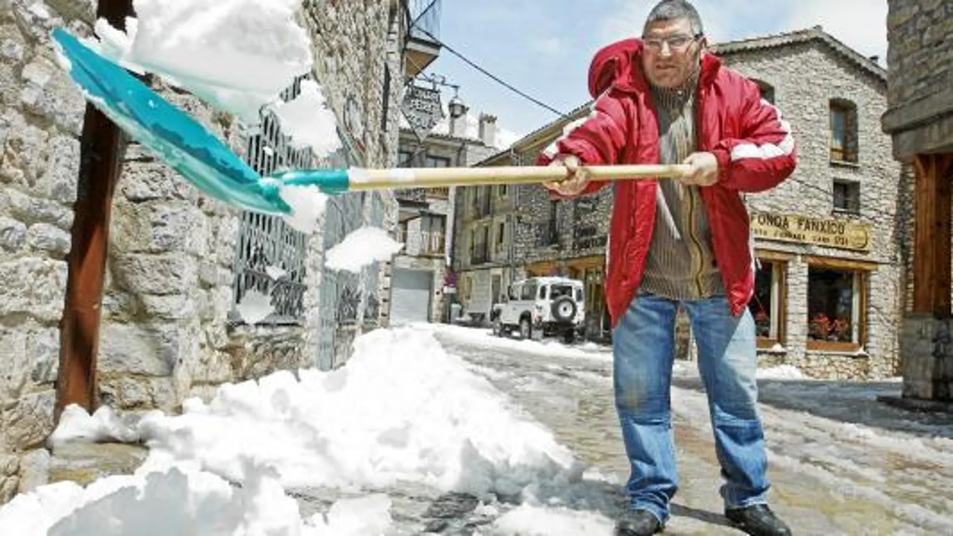 Un vecino de Castellar de N¿Hug retira nieve de la puerta de su casa tras la nevada que obligó a corta la carretera de acceso al municipio