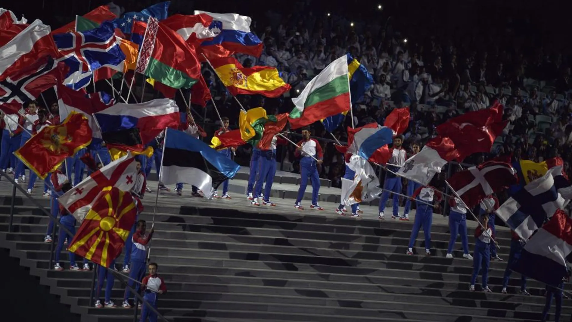 Varias personas ondean las banderas de los países participantes