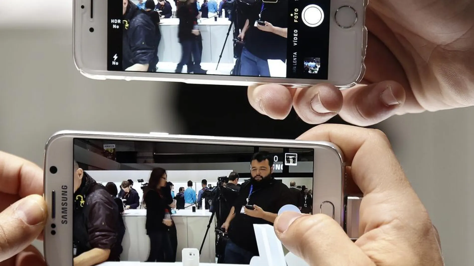 Un visitante compara la resolución de un Samsung Galaxy 6 y un Iphone (arriba) en el stand de Samsung en el Congreso Mundial de Móviles (MWC)