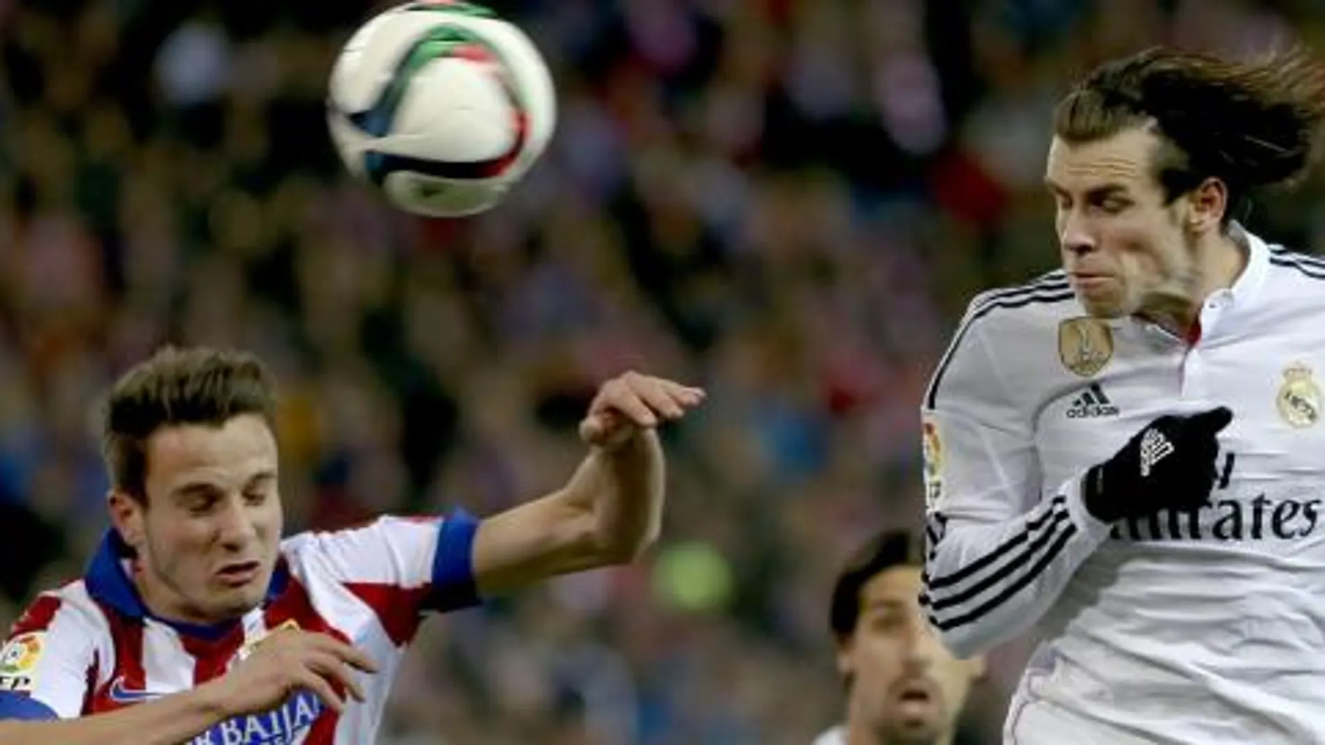 Saúl Ñíguez (i), salta por el balón con el galés Gareth Bale
